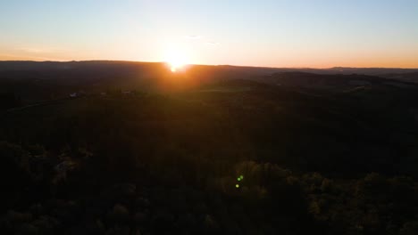 los rayos del sol se extienden y arrojan luz amarilla naranja dorada en las laderas onduladas de la toscana.
