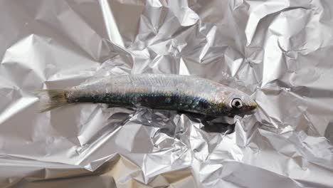 raw sardine on aluminum foil