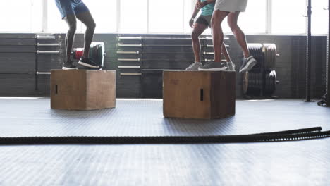 exercising in gym, men doing box jumps for fitness training workout