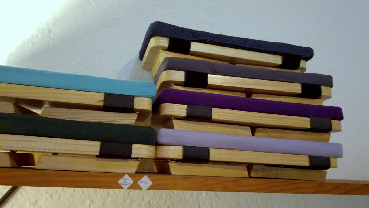 Cuscini da meditazione colorati impilati ordinatamente in un ambiente interno rilassante.
