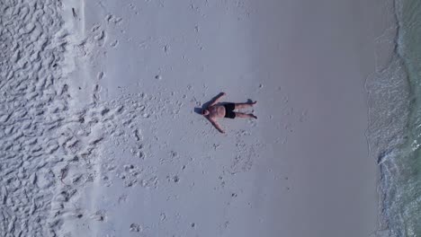 tourist lying on a beautiful tropical beach, enjoying the sun and the sound of the waves. breathtaking aerial view flight speed ramp hyper motion time lapse