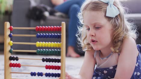 caucasian mother and daughter having fun using abacus