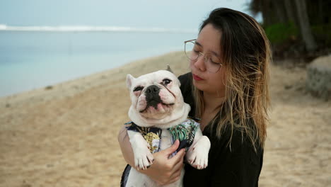 woman and dog having fun at the beach