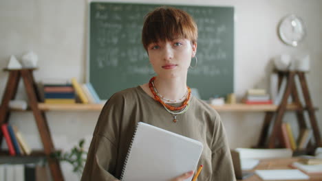 Portrait-of-Beautiful-Girl-with-Copybook-in-Classroom