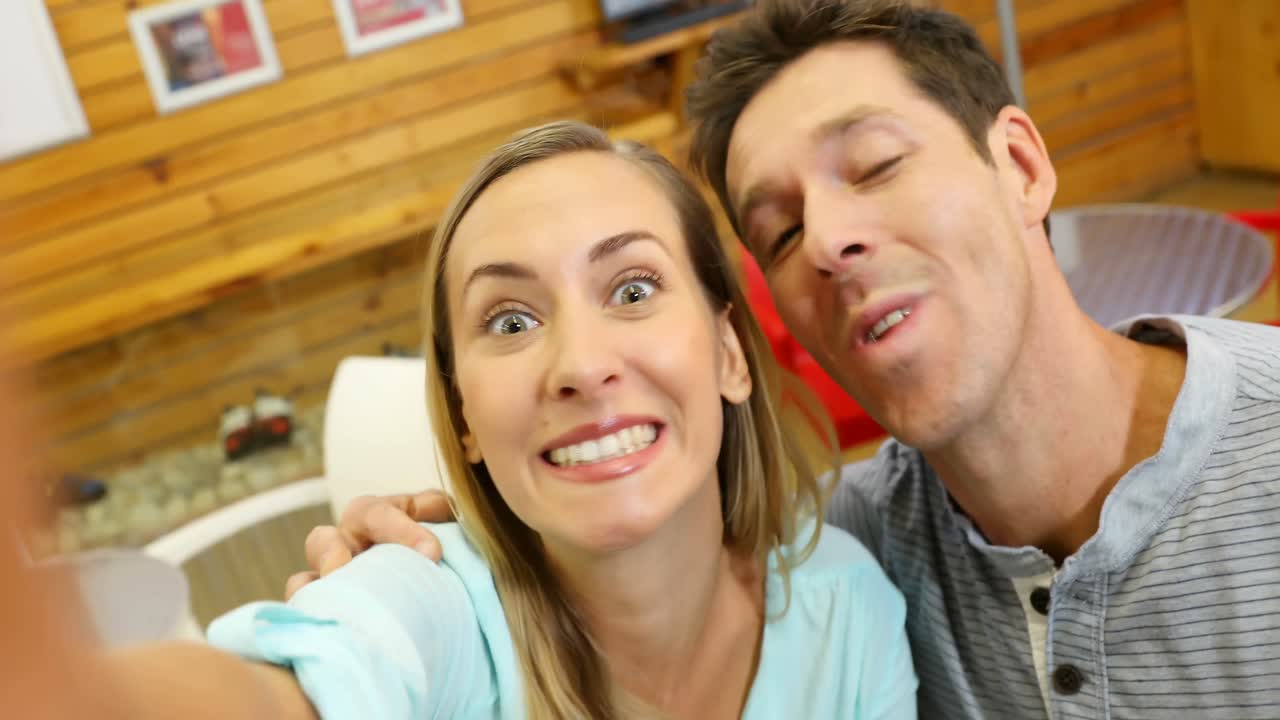 Happy couple making faces in cafe 4k