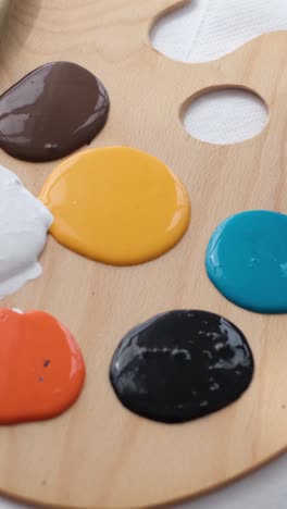 a close-up of a wooden artist's palette with various paint colors being prepared