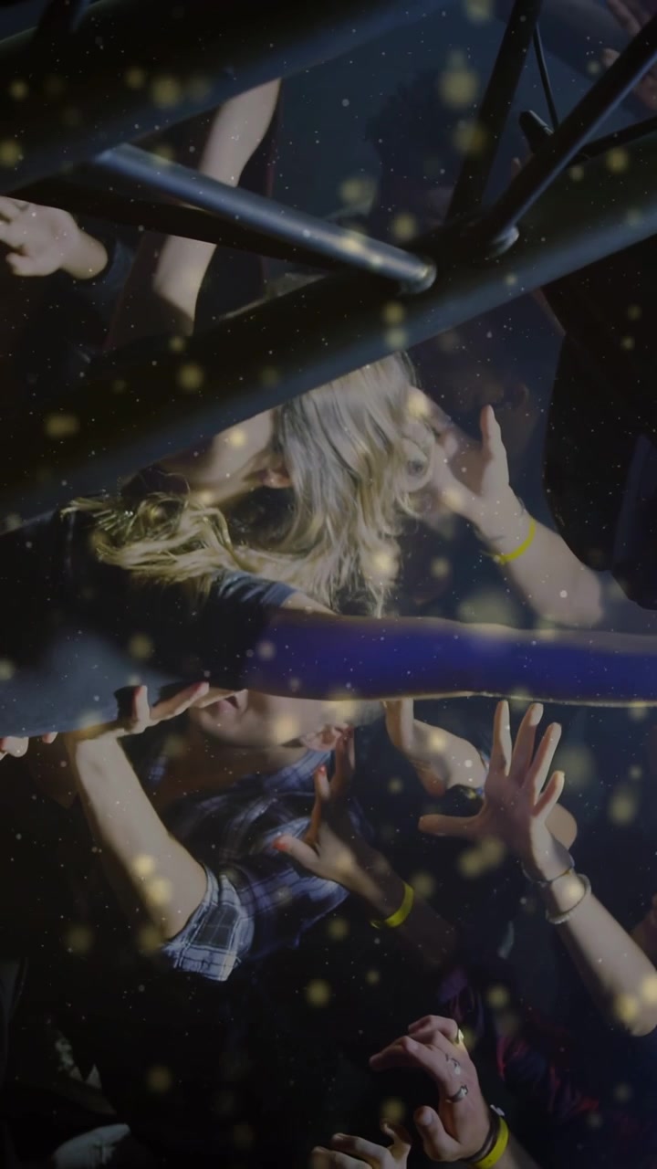 Vertical video: Concert crowd lifting woman to pass her forward, hands guiding amid confetti