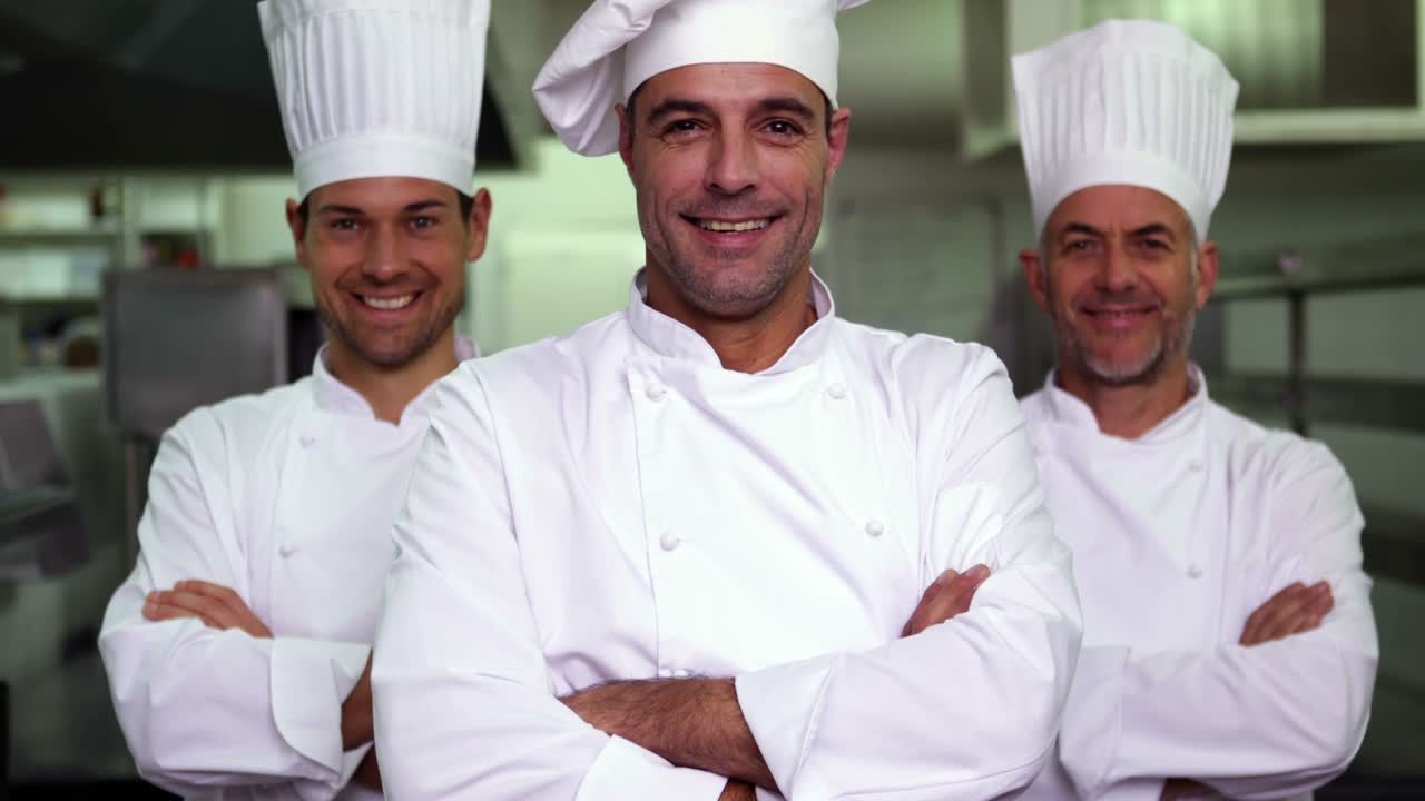 tres cocineros sonrientes mirando a la cámara haciendo una señal de ok