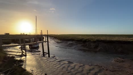 barcos atracados en el estuario con puesta de sol dorada