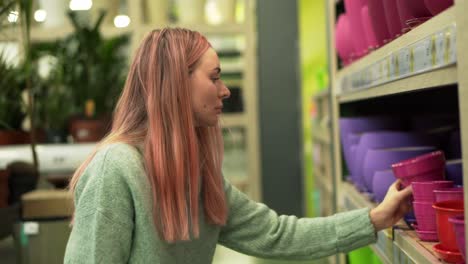 Woman-Choosing-Colorful-Pot-For-Home-Plants-From-Shelves-Of-A-Flower-Shop