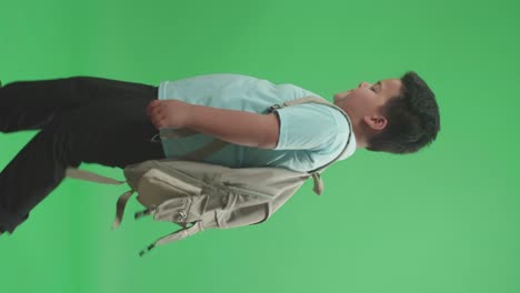 vista lateral de un estudiante asiático aburrido caminando a la escuela en pantalla verde tecla de croma