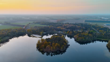 dutch sunset aerial view. aerial view over the peaceful dutch countryside, showcasing trees, water, and a serene sunset casting warm colors