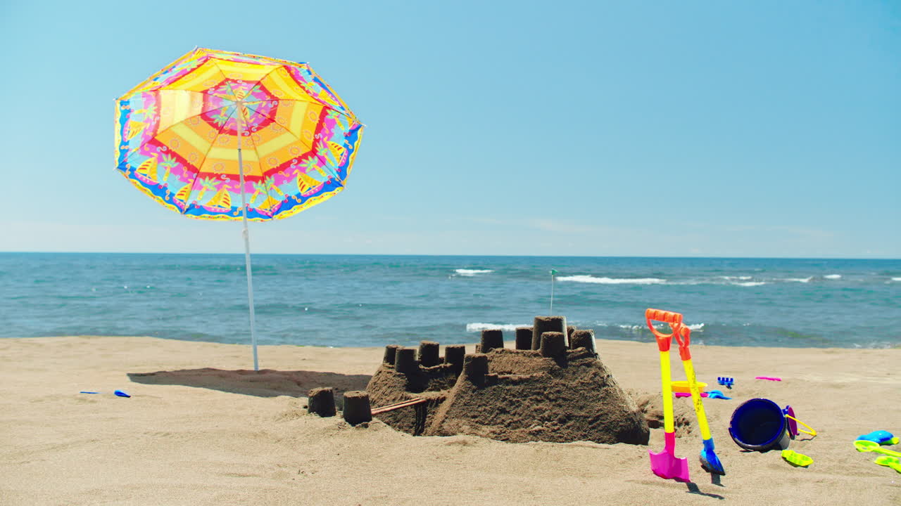 모래 성과 우산과 함께 해변 하루