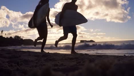 Pareja-Corriendo-Con-Tabla-De-Surf-En-La-Playa