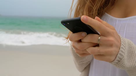 mid section of woman using mobile phone on the beach 4k