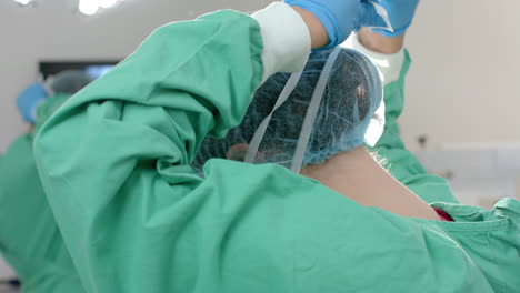 수술복과 모자를 입은 백인 여성 외과 의사가 수술실에서, 느린 동작