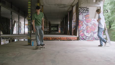 un niño caucásico patinando en un edificio en ruinas.