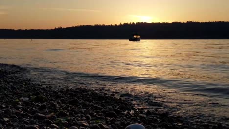 a lone motor boat slowly bobbing in the morning waves, anchored in puget sound, vashon island in the background, golden sunrise, gig harbor, washington, peaceful