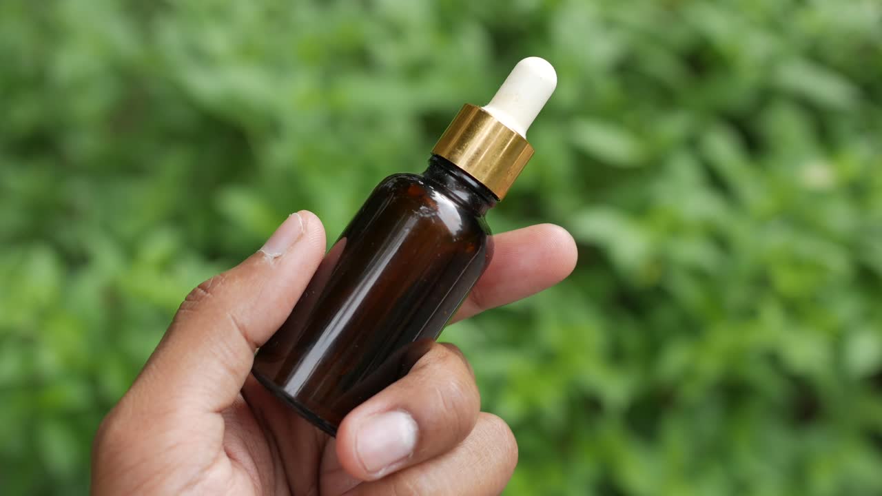 aceites esenciales de eucalipto en una botella de vidrio con hojas verdes en azulejos,