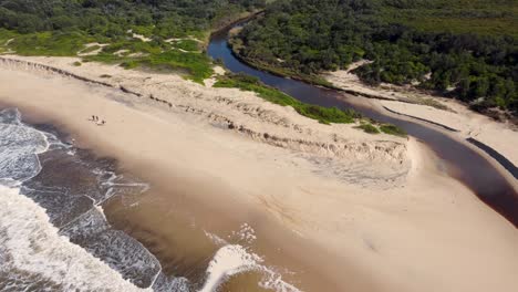 Aerial-drone-scenic-landscape-shot-of-Catherine-Hill-Bay-channel-on-Pacific-Ocean-beach-with-people-surfers-waves-Newcastle-Central-Coast-NSW-Australia-4K