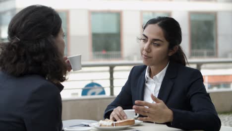 mujeres de negocios con tabletas en un café al aire libre