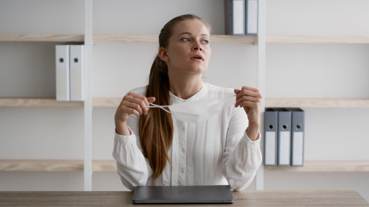 женщина корректирует маску в офисе