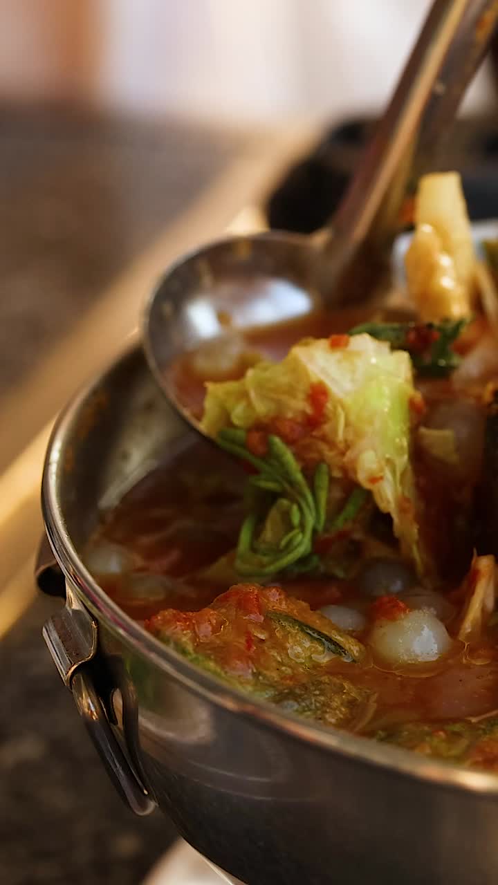 Ladle serving soup from a hot pot