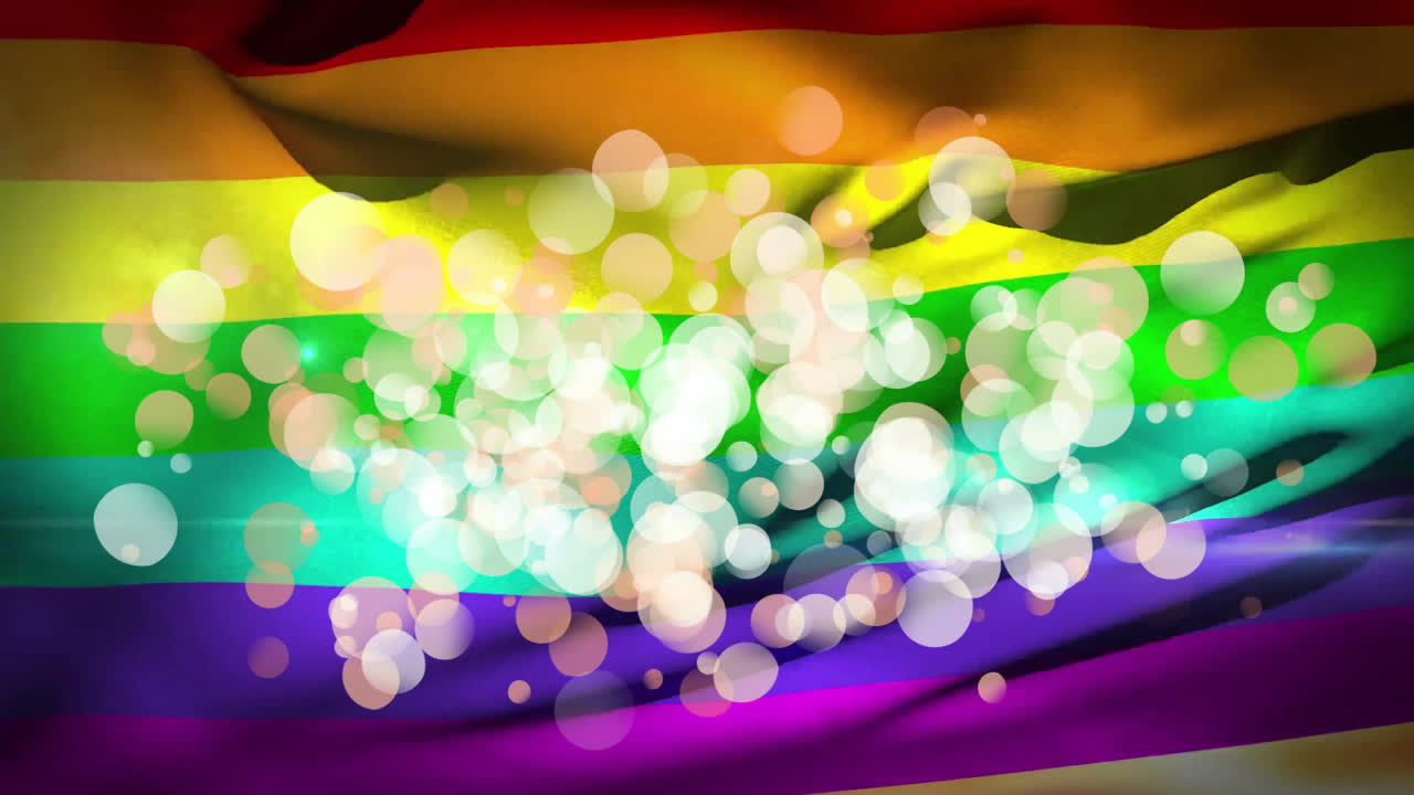 Rainbow flag waving across frame, showing bright stripes and soft bokeh overlay in flat design