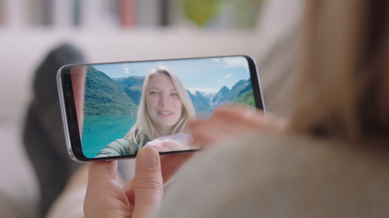 mujer joven chateando en video usando un teléfono inteligente amiga feliz de vacaciones en noruega compartiendo experiencia de viaje divirtiéndose en la aventura de vacaciones comunicándose con el teléfono móvil imágenes 4k