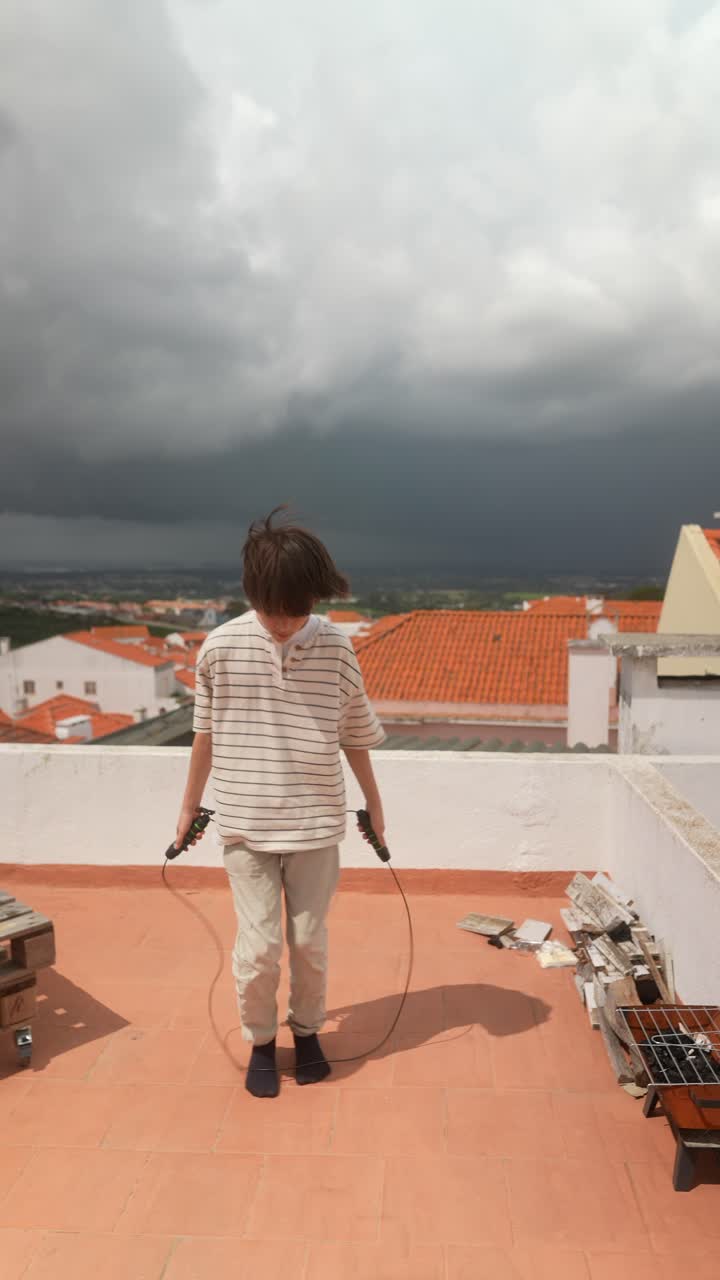 Boy Jumping Rope on Rooftop During Cloudy Day