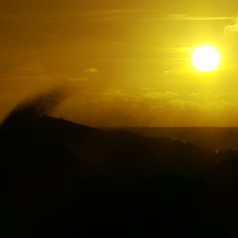 The-sunset-behind-waves-as-they-crest-and-break-in-slow-motion-at-sunset