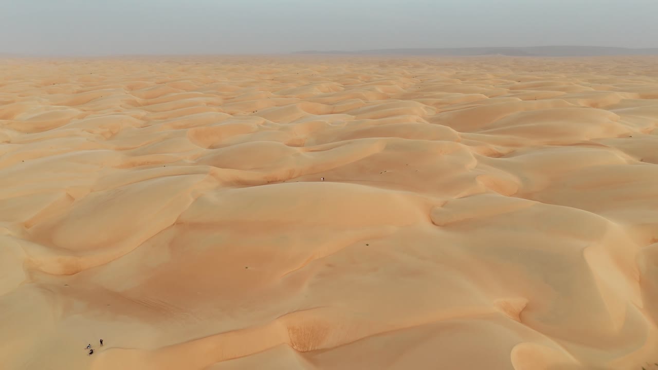 Mauritania Aerial, drone flight over the golden Azouiega sand dunes in the desert, showcasing sweeping curves, dramatic light and shadows, and vast untouched Sahara landscape