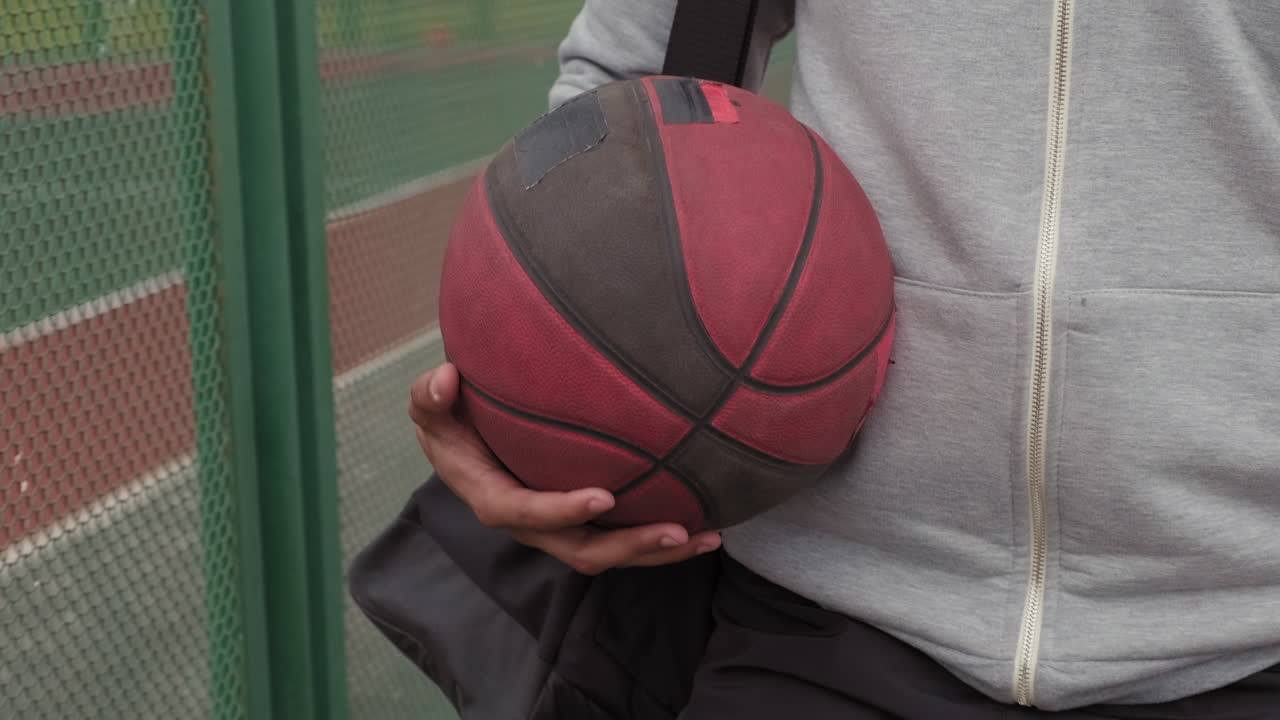Man with Dreadlocks Walking beside Outdoor Basketball Court