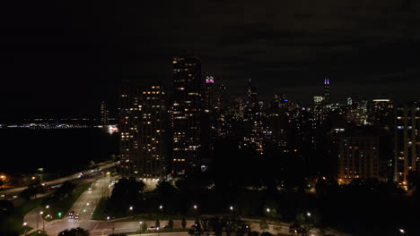 Im-Oktober-Fing-Eine-Drohne-Den-Panoramablick-Auf-Die-Skyline-Von-Chicago,-Illinois,-Ein,-Zu-Der-Eine-Reihe-Prächtig-Beleuchteter-Gebäude-Und-Fahrende-Autos-Auf-Der-Autobahn-Und-Dem-Michigansee-Gehörten