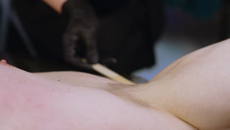 transparent gel is spread by the male armpit. preparation for the laser epilation. close up.