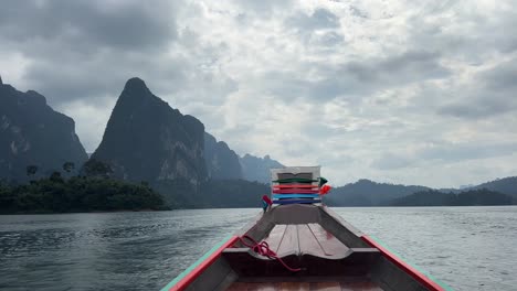 The-front-view-of-a-long-tail-boat-gliding-through-the-waters-of-a-lake