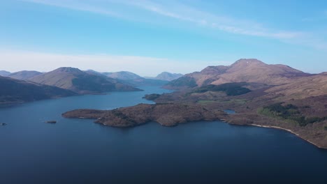 high angle approach of ben lomond and scottish mountains over loch lomond island on a sunny day
