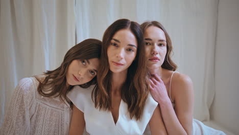 portrait three girls together looking camera. serene gorgeous ladies hugging