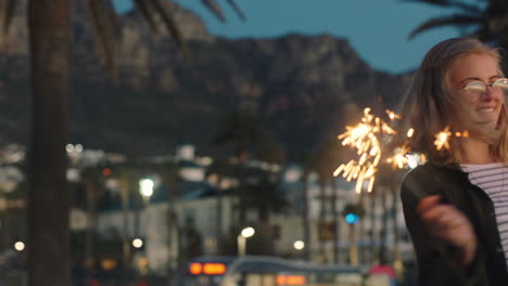 teenage girl dancing with sparklers on beach at sunset celebrating new years eve having fun independence day celebration with fireworks enjoying freedom