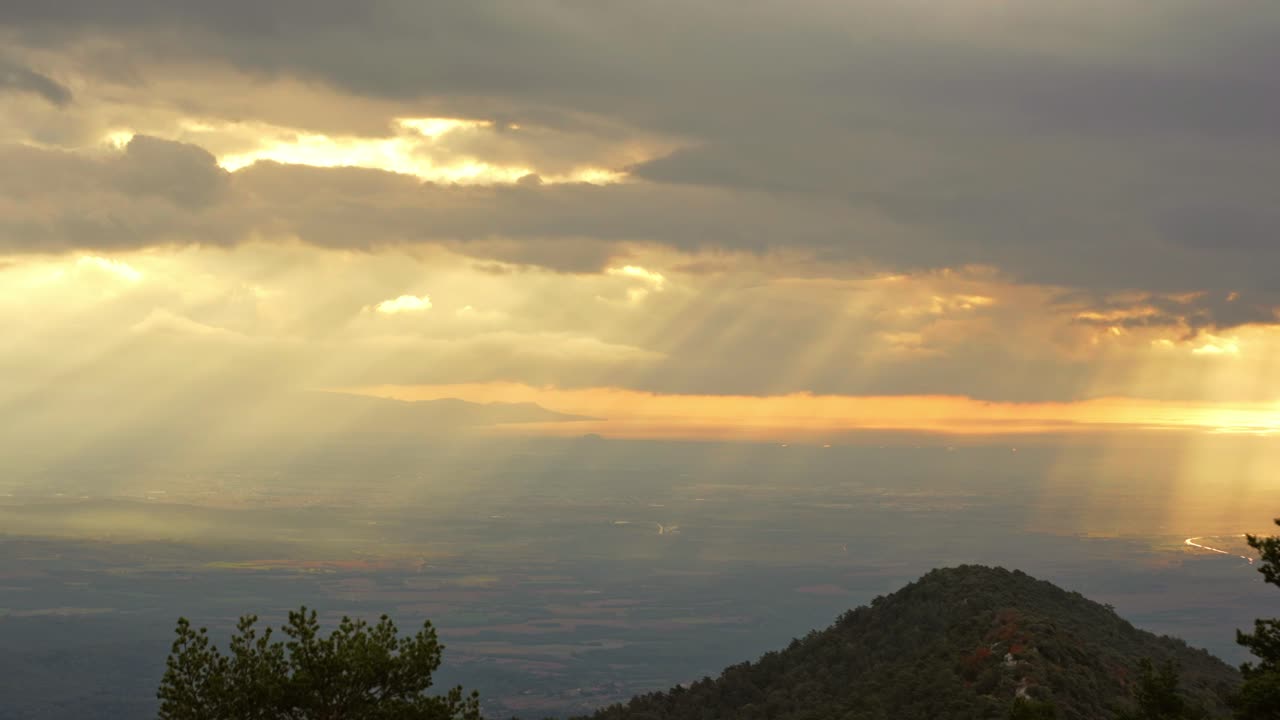 Sol y rayos de luz abriéndose paso entre las nubes sobre el paisaje de Cataluña