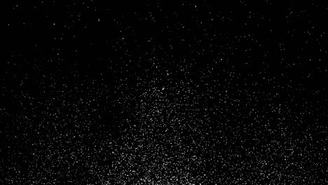 nieve blanca que cae rápidamente o pequeñas escamas abstractas sobre un fondo negro.