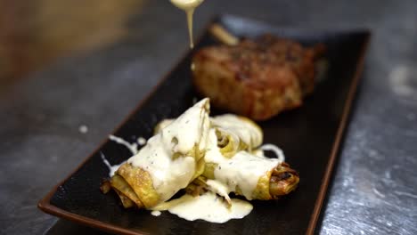 Pouring-sour-cream-onto-pasta-on-a-plate-of-food-in-slow-motion