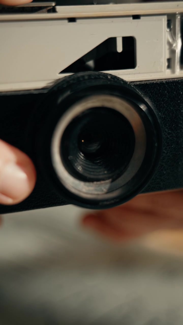 Vista ravvicinata di obiettivo di fotocamera vintage e mano