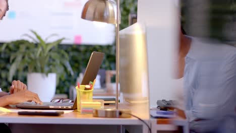 thoughtful african american casual businesswoman sitting at desk using laptop in office, slow motion