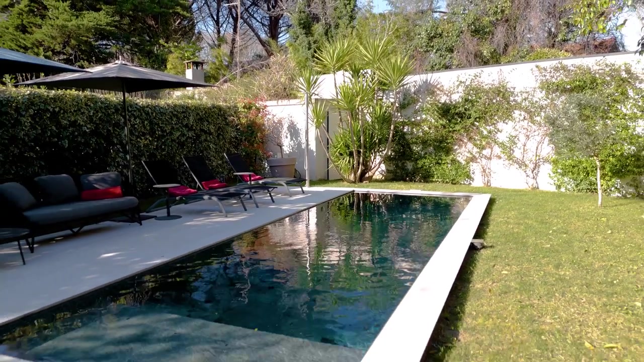 Aerial Drone Pull Out Above Swimming Pool in Luxury House Garden Location
