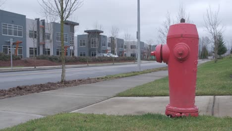 fire hydrant in a small industrial area with cars driving in the background