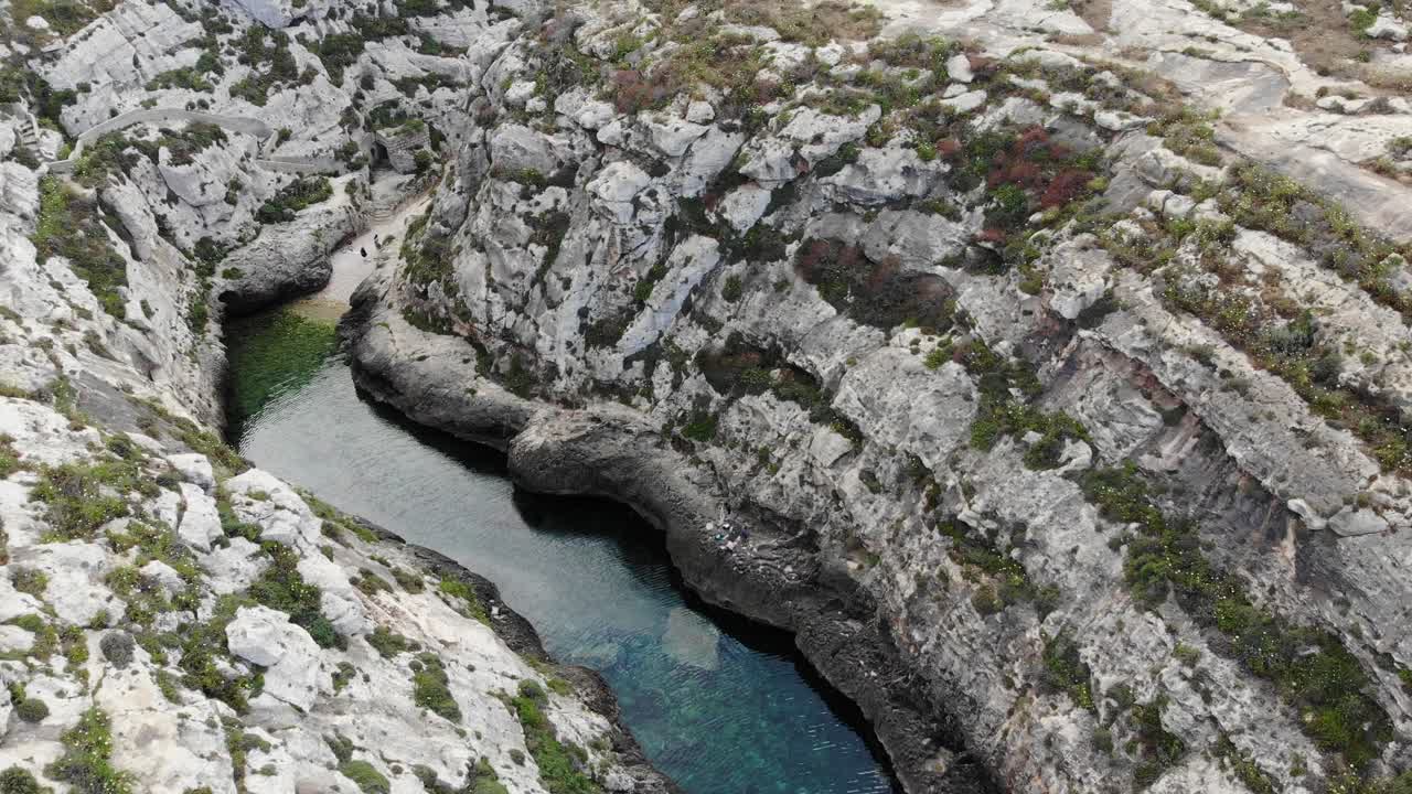 Malta, isola di Gozo, canyon del Mar Mediterraneo nella Valle di Ghasri, vista aerea di scogliera rocciosa e spiaggia nascosta.