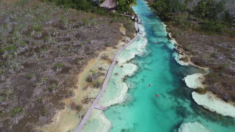 People-swimming-in-the-tropical-Mexico-river,-Rapids-of-Bacalar,-aerial-view
