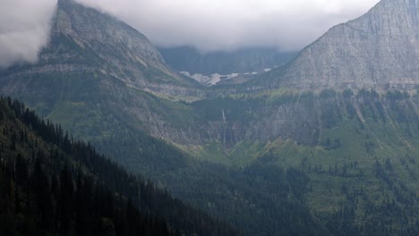 Hermoso-Paisaje-En-El-Parque-Nacional-Glaciar-Montana-En-Condiciones-Tormentosas-De-Invierno-Con-Una-Cascada-Distante-Del-Glaciar-Que-Se-Derrite-Justo-Encima