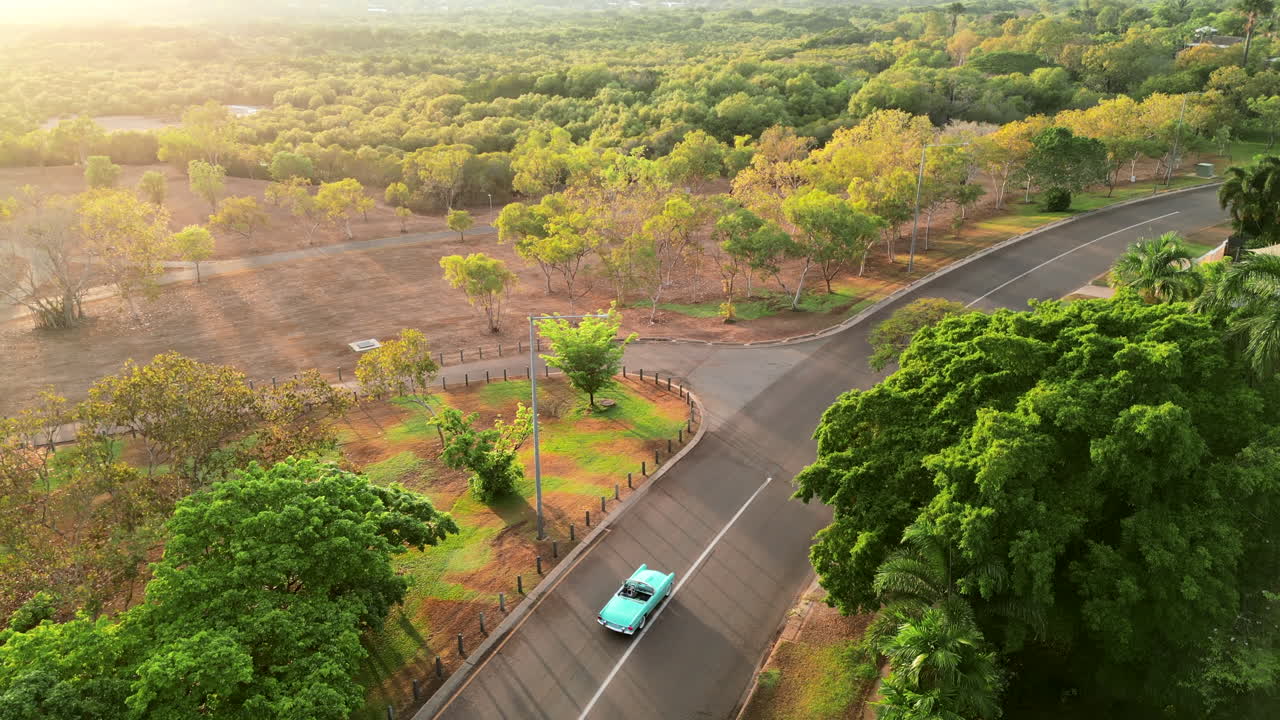antena de drones de coche retro azul verde azulado por un largo y sinuoso camino hasta el río